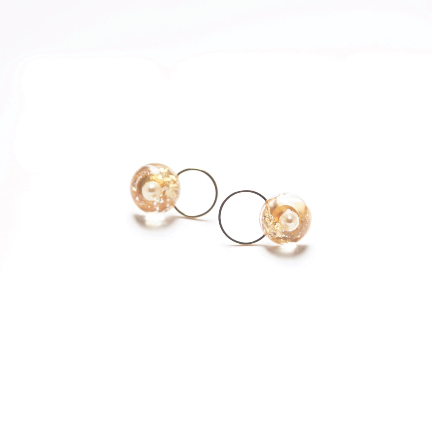 Golden hoop earrings with Circle Art resin design, adorned with a delicate freshwater Pearl and golden leaf accent